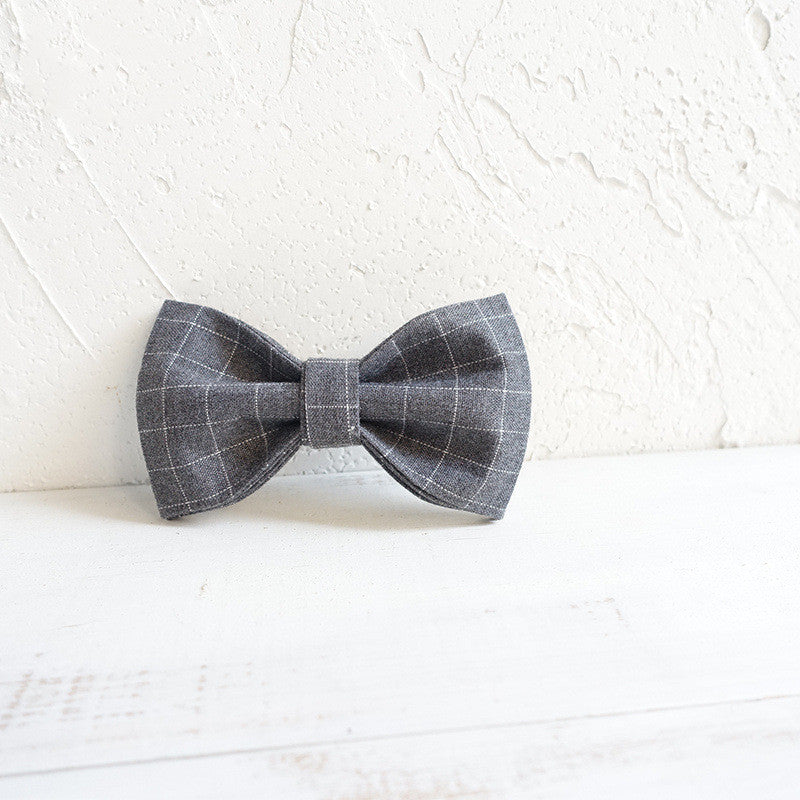 Gray checkered bow tie on a textured white background