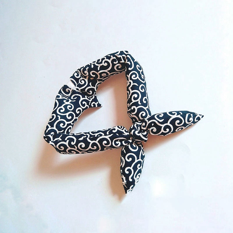 Black and white patterned scarf tied in a knot on a light background