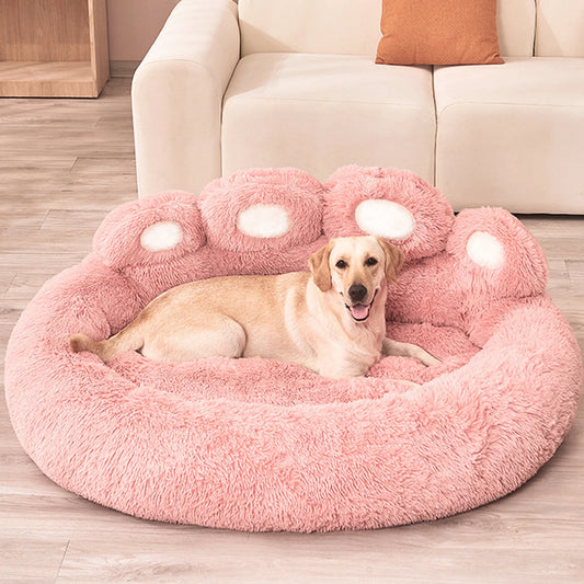 Dog lying on a pink paw-shaped pet bed in a living room.