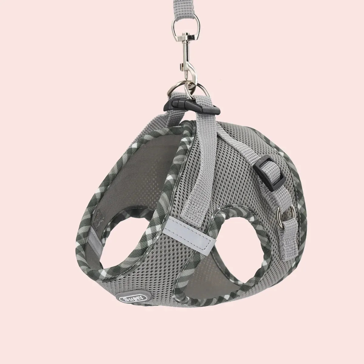 Dog muzzle with gray straps on a pink background