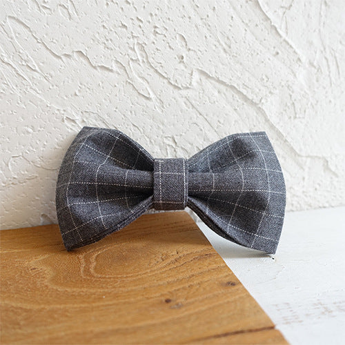 Plaid bow tie on a wooden surface with a white textured background