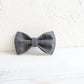 Gray checkered bow tie on a textured white background