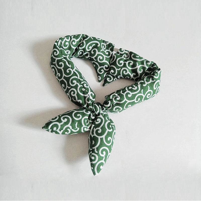 Green and white patterned scarf on a light gray background
