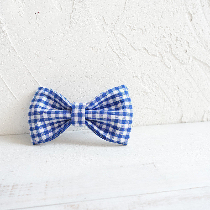 Blue and white checkered bow tie on a textured white background