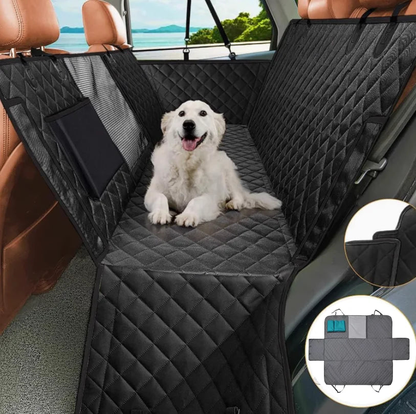 Dog sitting on a black car seat cover with a quilted pattern, inside a vehicle.
