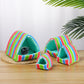 Colorful striped pet house on a wooden surface with a white background