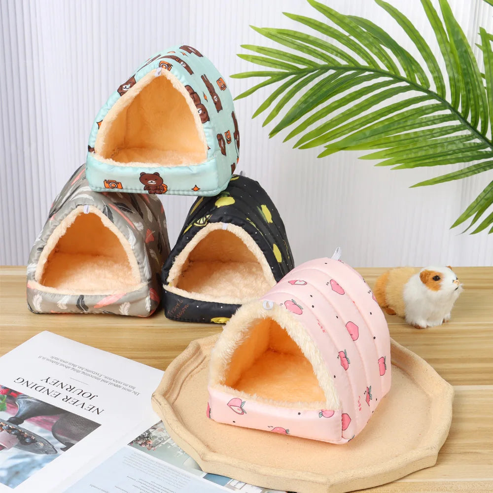 Four small pet houses with different patterns on a wooden surface.