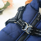 Close-up of a black dog harness on a blue jacket with a blurred background