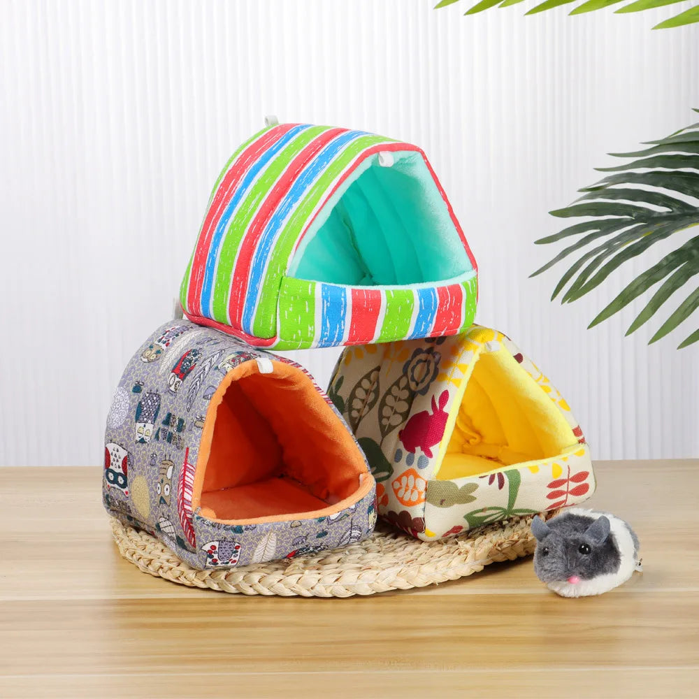 Colorful pet house with a small gray mouse on a wooden surface.