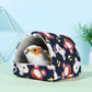 Pet bed with cartoon animal pattern containing a small white and brown pet on a light blue background
