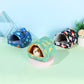 Three colorful pet beds on a light green surface with a light blue background