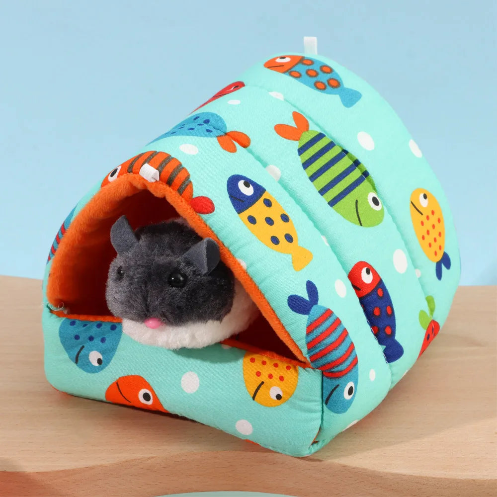 Small animal house with fish pattern on a wooden surface and light blue background