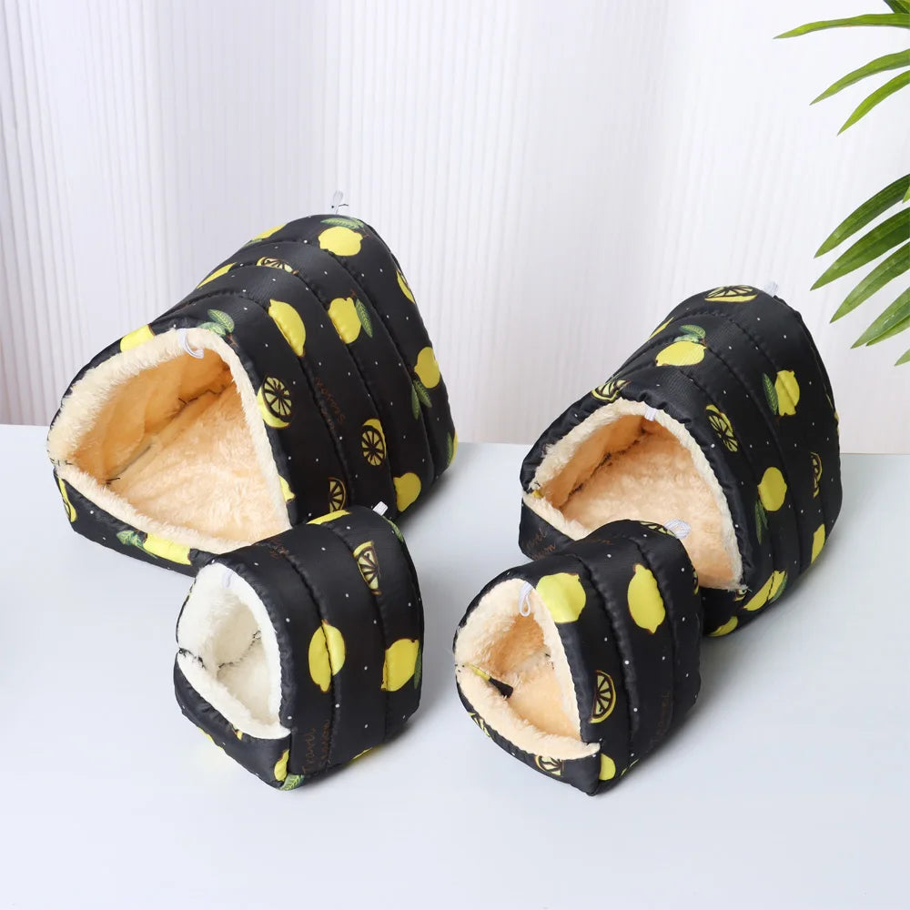 Pair of black slippers with yellow lemon pattern on a white surface.