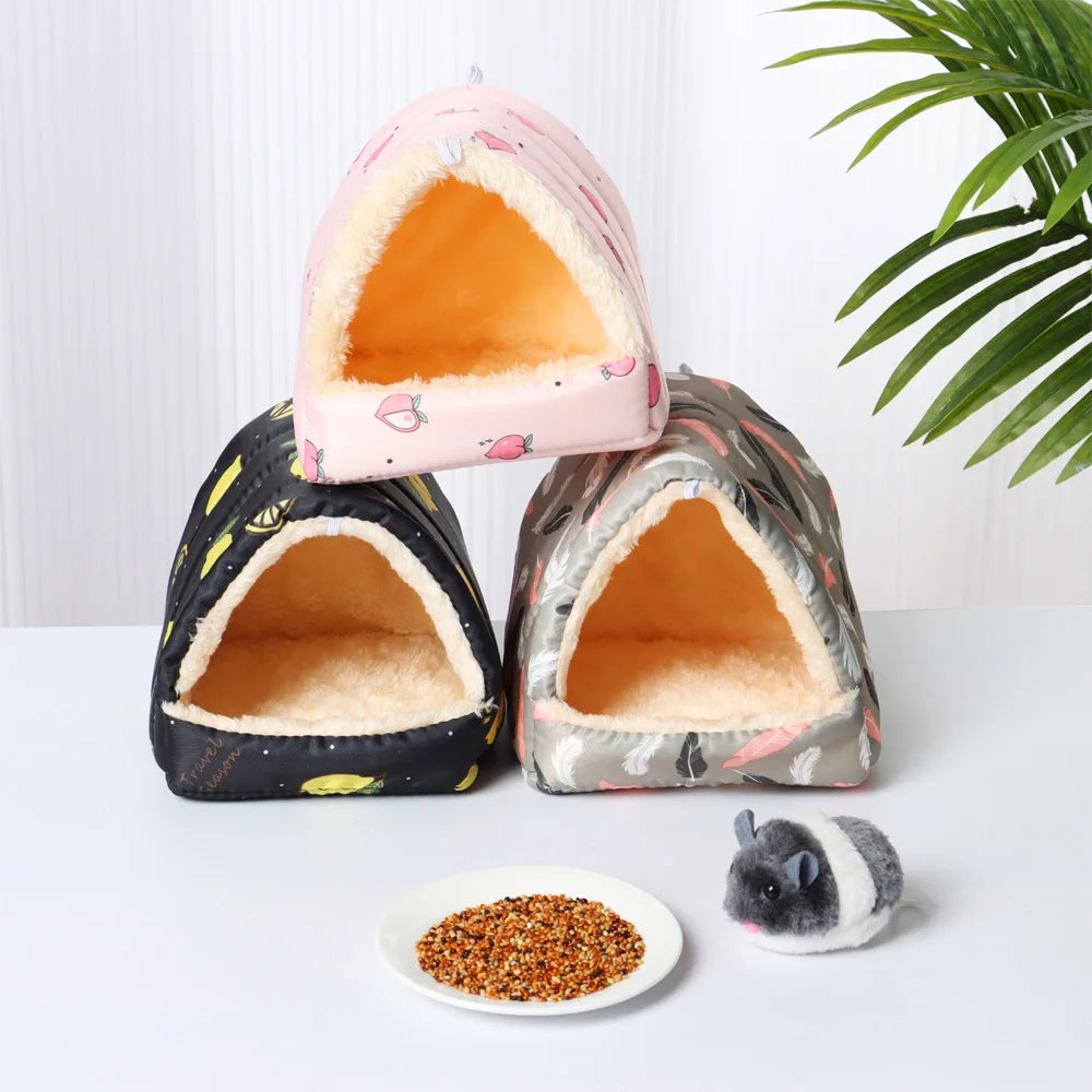 Three pet houses with a small plate of food and a toy on a white surface.