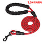 Red dog leash with black handle and clip on a white background
