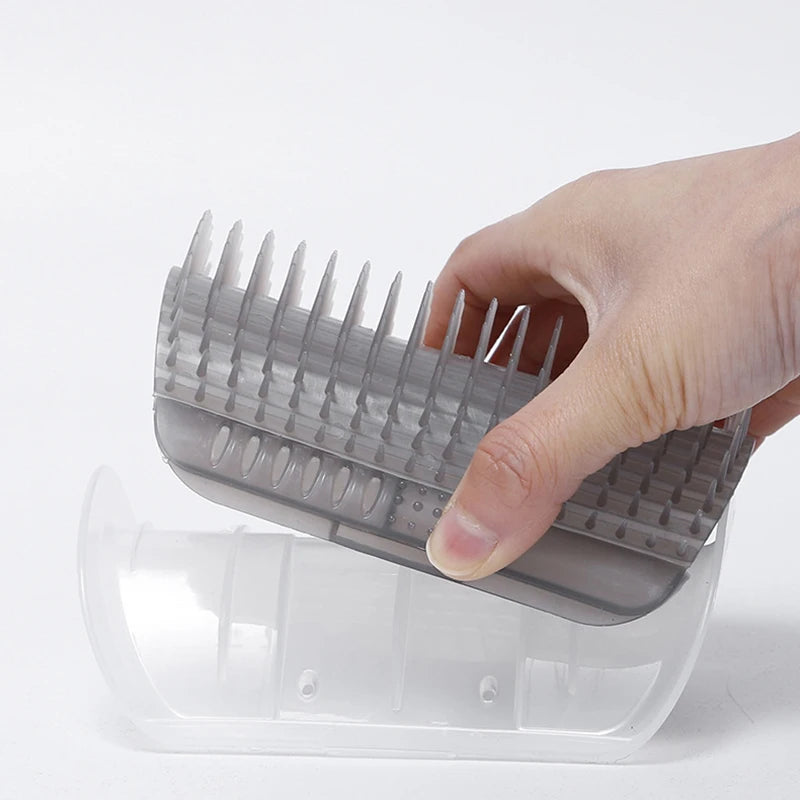 Hand holding a gray grooming comb over a transparent plastic container on a white background