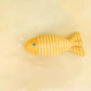 Yellow fish-shaped toy on a beige background