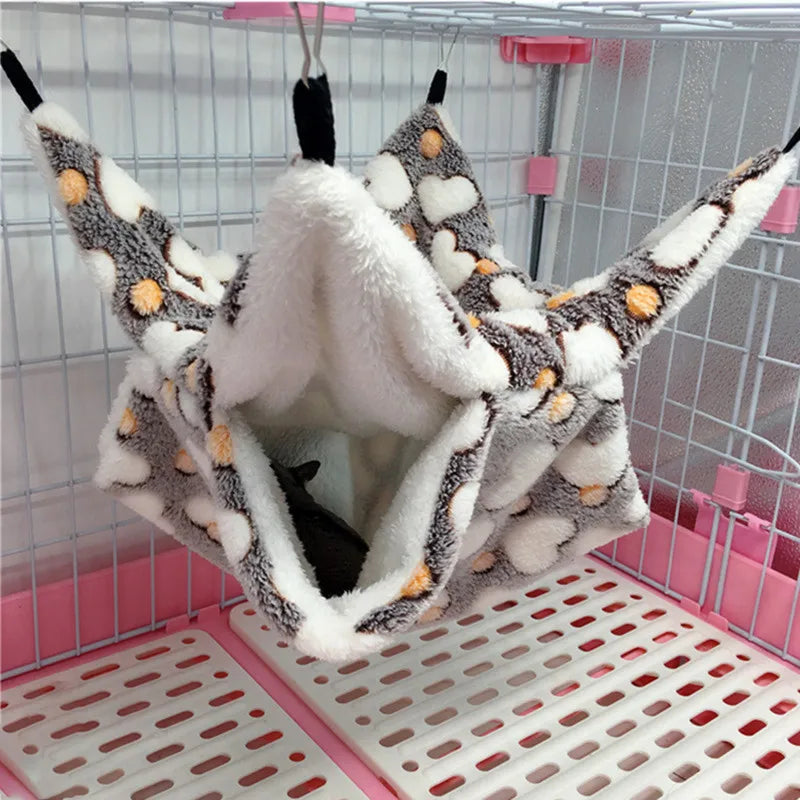 Pet hammock with plush interior hanging inside a pet cage.