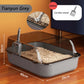Cat litter box with scoop on a wooden floor, featuring dimensions and a deliver logo.