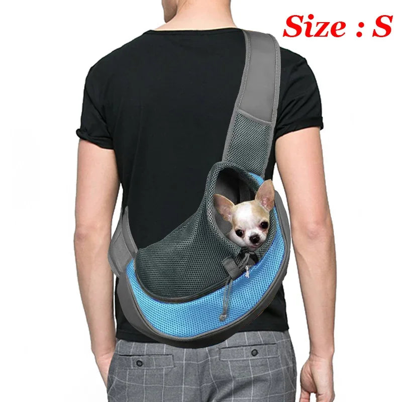 Person wearing a blue pet sling with a small dog peeking out, on a white background.