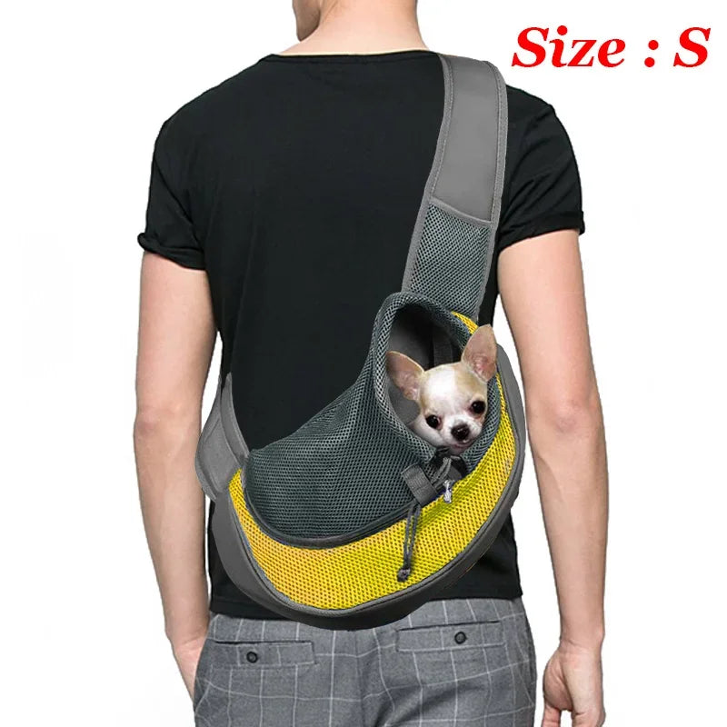 Person wearing a gray and yellow pet carrier with a small dog inside, on a white background.