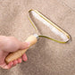 Hand holding a lint roller on a beige carpet
