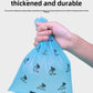 Hand holding a blue pet waste bag with text highlighting features on a light gray background