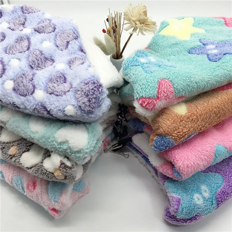 Stack of colorful plush blankets with various patterns on a white background