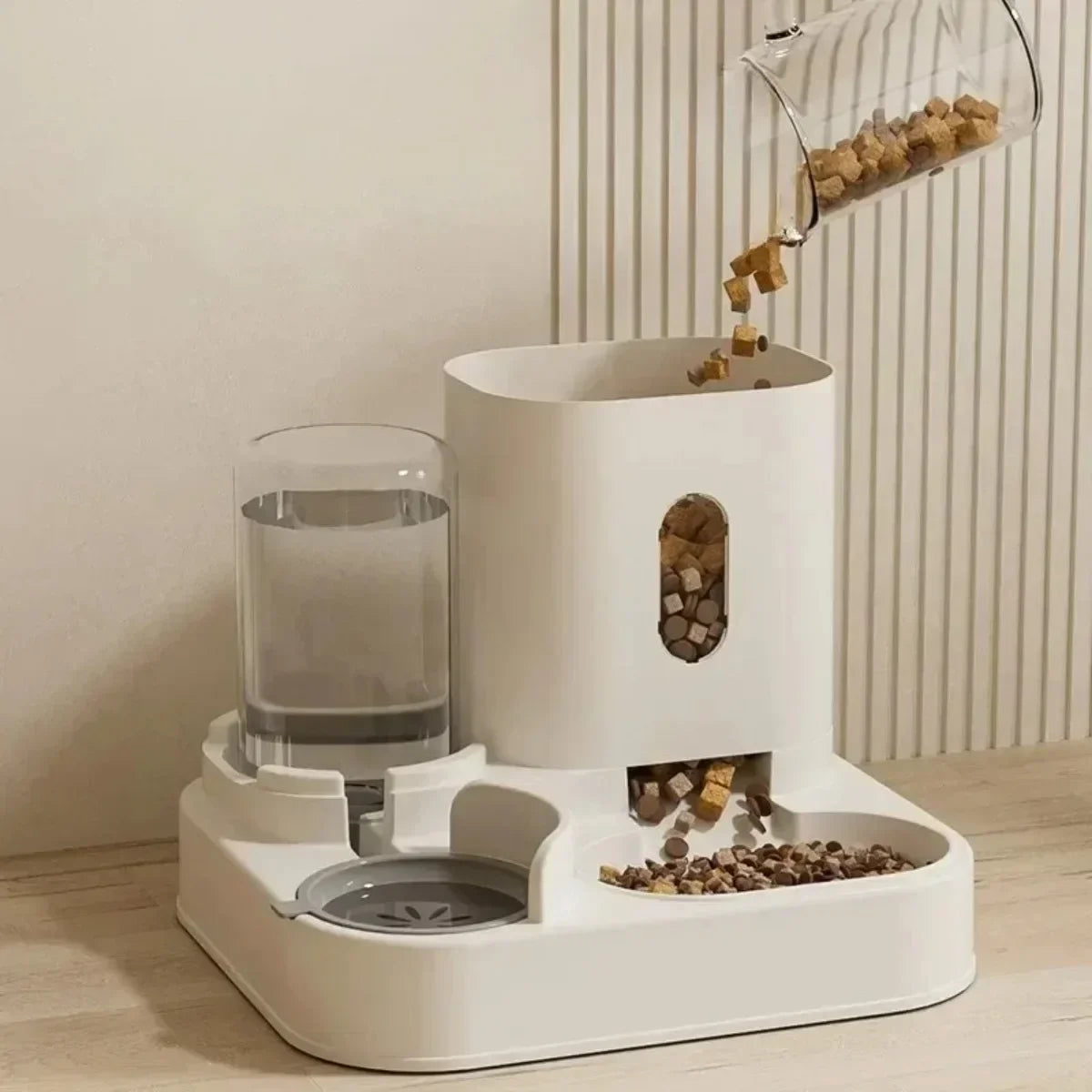 White pet feeder with water bowl and food dispenser on a light wooden floor.