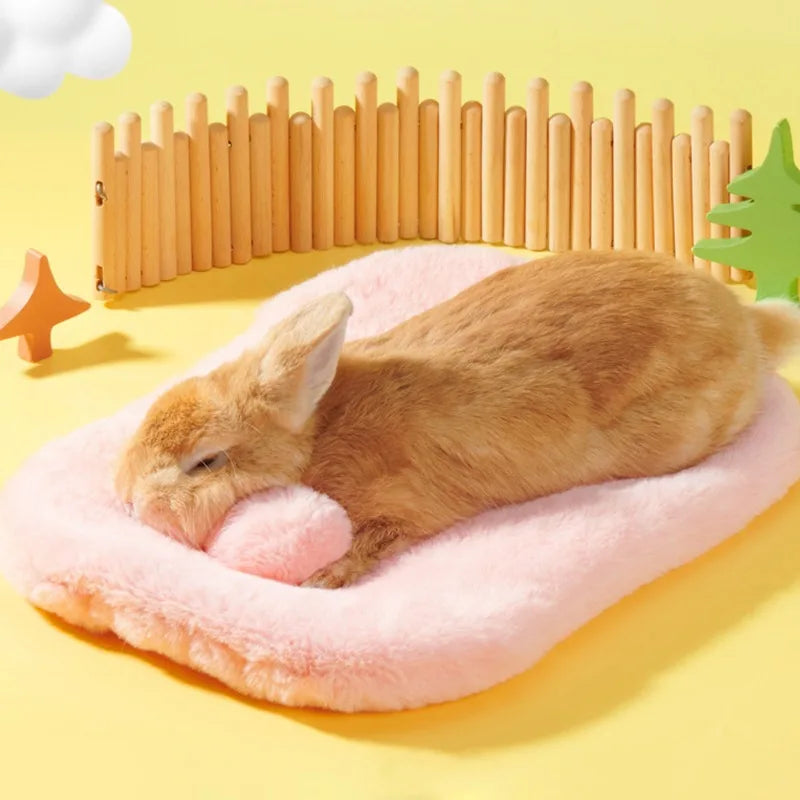 Brown rabbit sleeping on a pink cushion with a wooden fence and decorative items in the background.