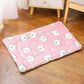 Pink rug with white cat patterns on a wooden floor