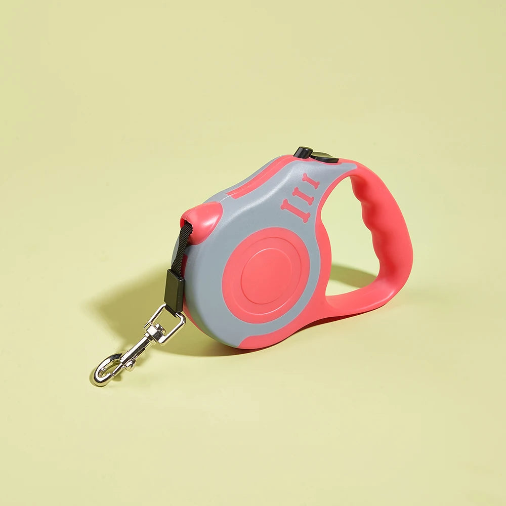 Retractable dog leash with red handle and gray reel on a light yellow background
