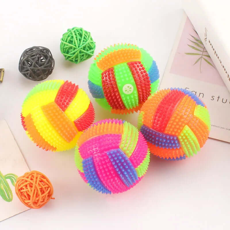 Colorful textured balls on a light surface with a magazine in the background