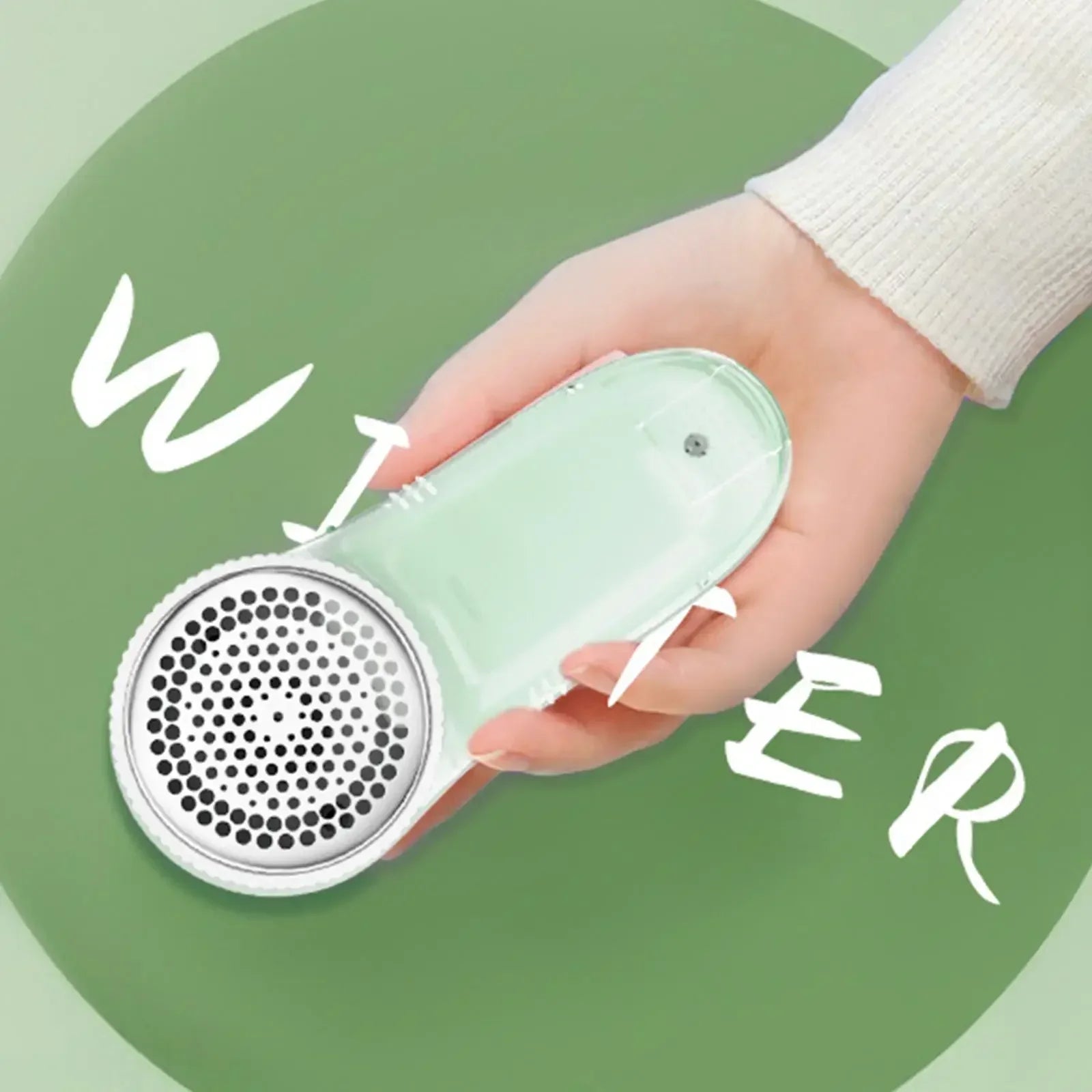 Hand holding a green fabric shaver with a green background