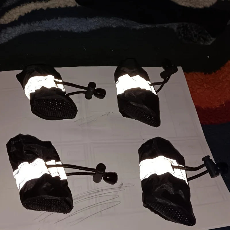 Four black and white socks with reflective stripes on a white surface.