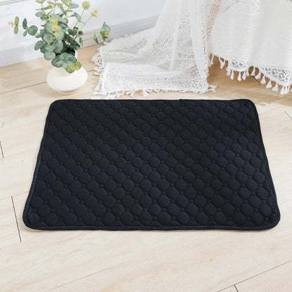 Black quilted mat on a light wooden floor with a plant and white lace fabric in the background.