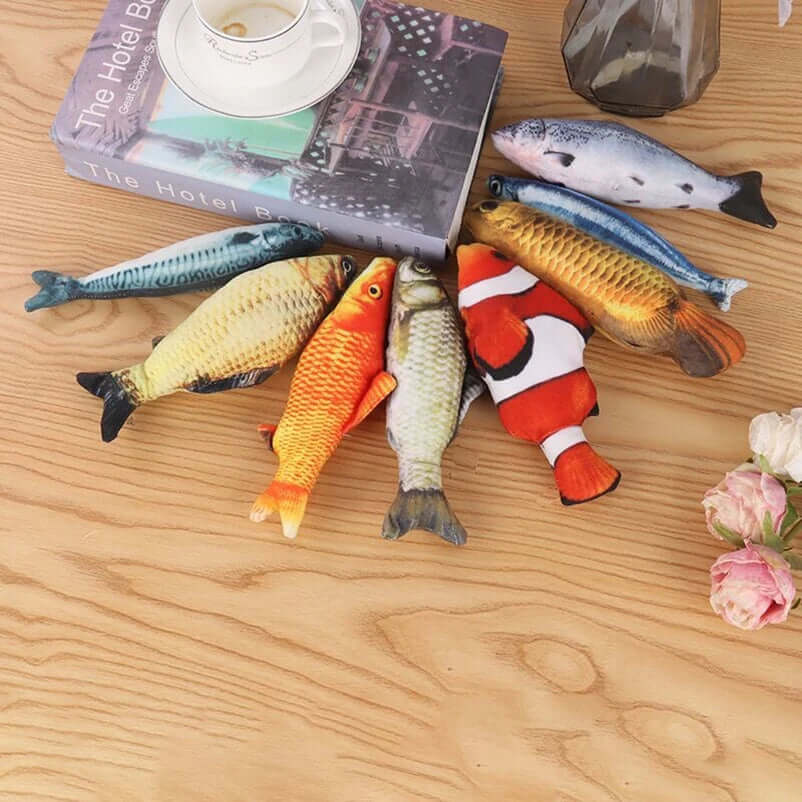 Colorful fish-shaped toys on a wooden surface with a book and flowers.