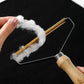 Person using a fabric shaver with cotton fibers on a black background