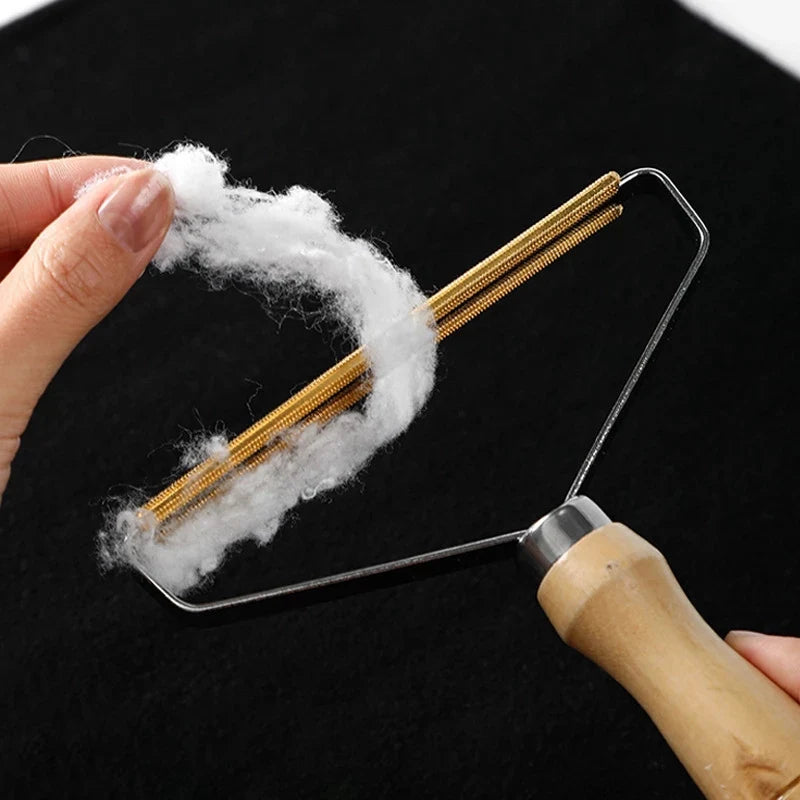 Person using a fabric shaver with cotton fibers on a black background