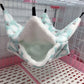 Pet hammock hanging inside a cage with a white and light blue design.
