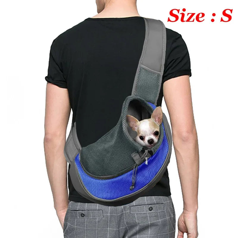 Person wearing a blue and gray pet carrier with a small dog inside, on a white background.