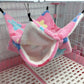 Pink pet hammock with colorful accents hanging inside a pet cage.