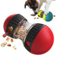 Red and black pet toy with food inside, dog interacting with it on a white background