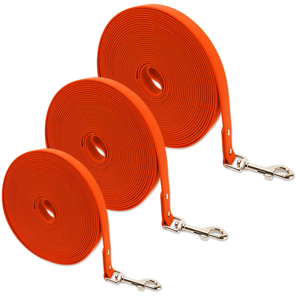 Three orange dog leashes with metal clips on a white background