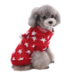 Small dog wearing a red sweater with white star patterns on a white background