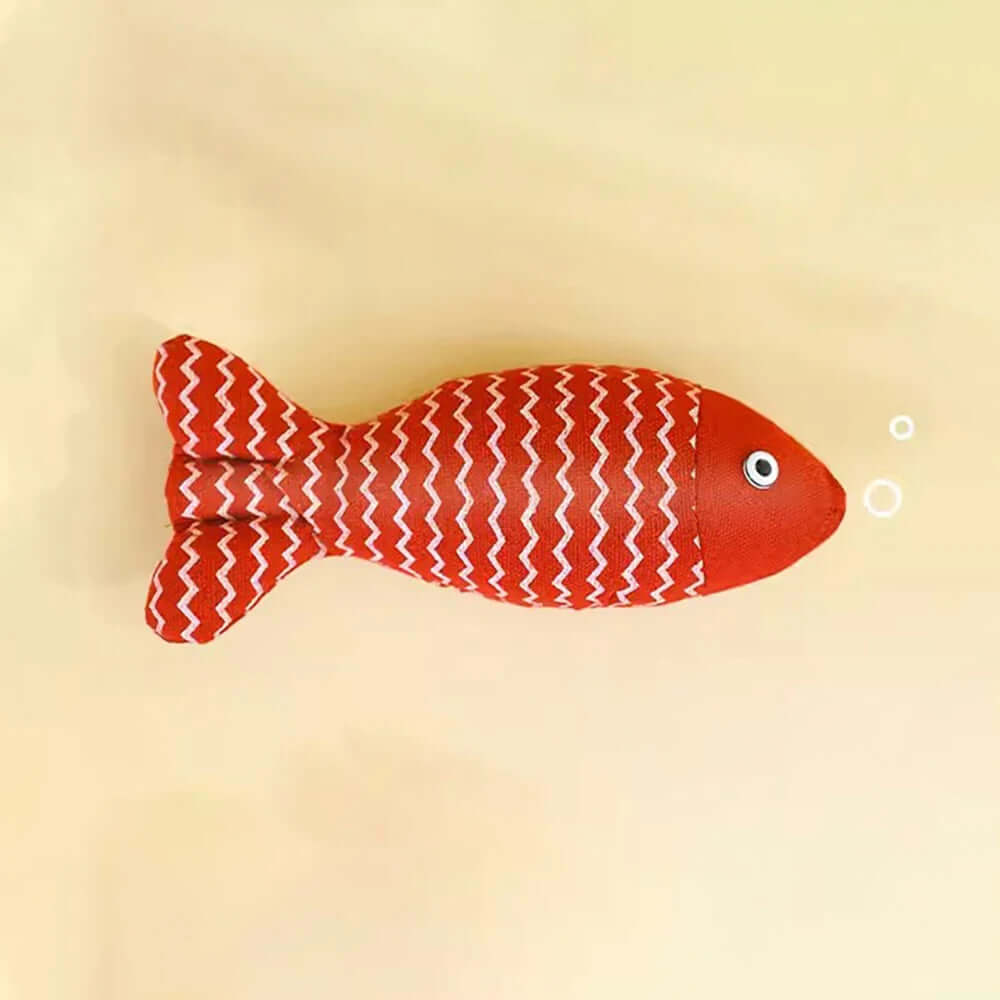 Red fish-shaped toy with white pattern on a beige background