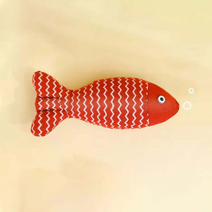 Red fish-shaped toy with white pattern on a beige background