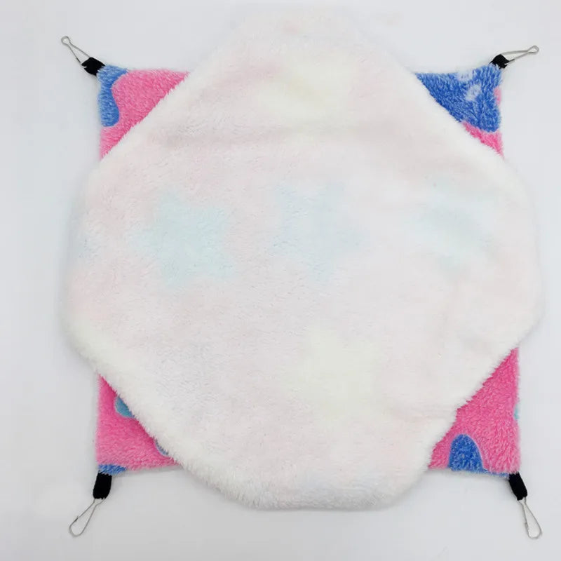 Round white plushie with pink and blue accents on a white background