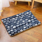 Navy blue pet bed with white animal pattern on a wooden floor
