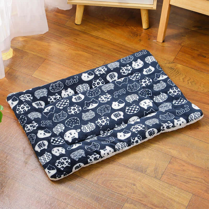 Navy blue pet bed with white animal pattern on a wooden floor